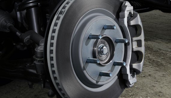 Close-up of a vehicle's disc brake rotor and silver brake caliper assembly